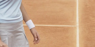 女孩用球拍打网球，在场上热身，近距离