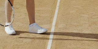 女子发球打网球，穿着舒适的运动鞋进行积极运动，双腿收起来