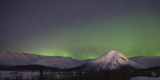 冬夜星空与雪山绿光的时间流逝。