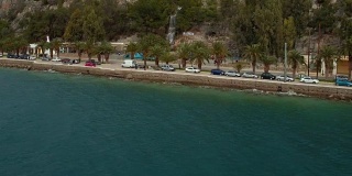 空中-劳特拉基-希腊，向后显示的海岸道路与棕榈树和瀑布