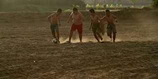 慢镜头，农村的孩子们在阳光明媚的日子里踢足球。