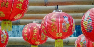 中国新年的灯笼挂在竹木上，祝福文字意味着拥有财富和幸福