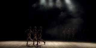 一群孩子在黑暗中在舞台上跳芭蕾舞。