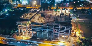 4k延时:建筑工地上起重机和工人在夜间的鸟瞰图