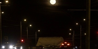 十字路口Ñar乘坐包括交通灯。夜路与灯笼离开，在满月的远方。