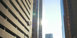 驱车穿过市中心的办公楼，沐浴在清晨的阳光中