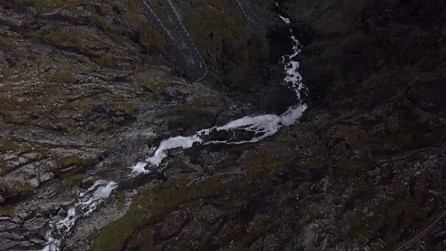 4K鸟瞰图瀑布流下悬崖的Trollstigen路与山区森林