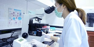 科学家在实验室里观察显微镜的多莉镜头