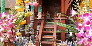 泰国园林中的传统佛坛装饰精美，有鲜花和各种象征人物