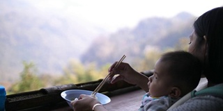 妈妈和宝宝在山顶吃面条