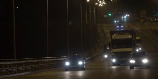 夜间公路交通车辆。傍晚，汽车在桥上行驶。黑暗中的高速公路
