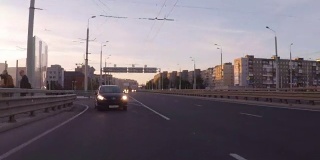 开着车穿过夜晚的城市。日落时，汽车在城市的高速公路上行驶。城市景观。时间流逝。加里宁格勒- 2017年7月俄罗斯。