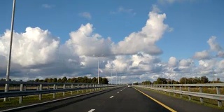 4K /超高清视频片段。POV高速公路公路移动云时间流逝。云在天空中移动，在多云的下午，在高速公路景观的时间间隔。超速驾驶镜头