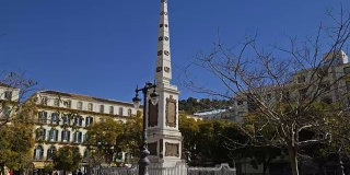 西班牙马拉加。大约在2018年3月。游客参观纪念托里霍斯将军的方尖碑在广场德拉默塞德，受欢迎的广场在历史中心。
