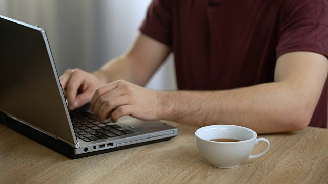 男作家在家里用手提电脑打字喝茶，自由撰稿人，记者