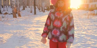 一个小女孩在森林里朝着冬日的夕阳走去
