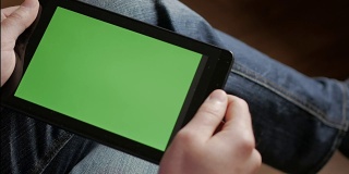 一个在工作场所使用绿色屏幕的平板电脑的人，滚动新闻，查看财务报告，点击屏幕。手顶视图。4K手持商务金融智能手机CHROME KEY