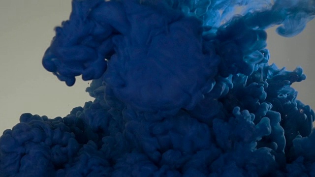 蓝色油漆倒入水中。丙烯酸颜料和油墨在水中。抽象的背景帧。颜色和墨水在水中