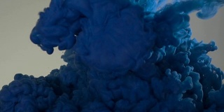 蓝色油漆倒入水中。丙烯酸颜料和油墨在水中。抽象的背景帧。颜色和墨水在水中