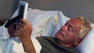 悲伤的老人躺在床上看相框视频素材模板下载