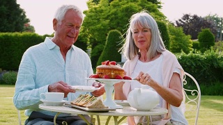 一对退休夫妇在家花园里享用下午茶视频素材模板下载