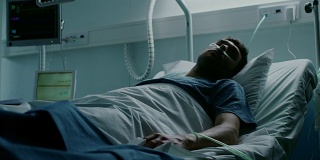 在医院里，一名绝症患者躺在床上忍受痛苦。年轻男子在姑息治疗病房。