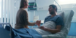 医院里，一个男人躺在床上康复，充满爱心的妻子来看他。他们彼此拥抱，彼此相爱，