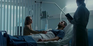 在医院里，病人躺在床上，他的妻子听医生解释病人的病情。疾病、痛苦和死亡主题。有希望的亲人。