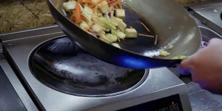 厨师在热锅中混合油炸材料