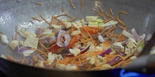厨师在热锅里拌炒蔬菜