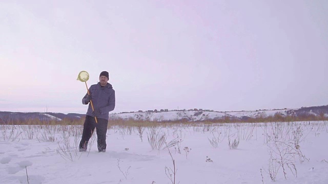 一个男人在雪地里挥舞着网