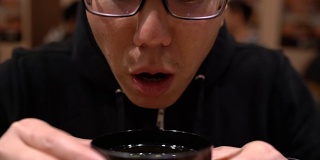 亚洲人在日本餐厅喝汤