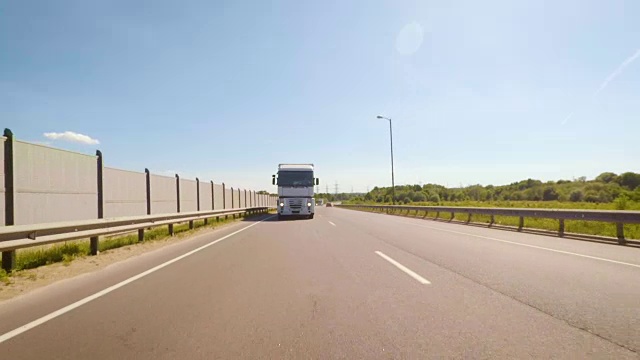 卡车在欧洲公路上行驶。前视图的白色卡车在道路上