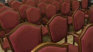 许多木制椅子的特写。戏院里一排排空椅子。镶花地板。视频素材模板下载