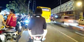 骑摩托车在夜间亚洲道路交通的观点。时间流逝。泰国,芭堤雅