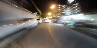 骑摩托车在夜间亚洲道路交通的观点。时间流逝。泰国,芭堤雅