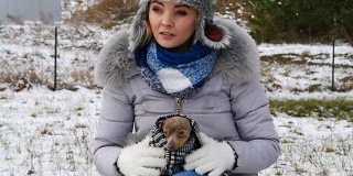 忧心忡忡的女人在冬天照顾小狗