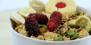 美味营养，轻脆的米片和小麦在碗上的木桌上，与浆果水果，低脂肪更多的蛋白质和叶酸，与浆果和水果。有选择性的重点。