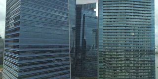 航拍图:飞向空荡荡的大街附近冰冷的玻璃现代摩天大楼。