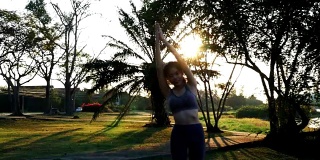 young woman exercise , arm outstretched with sun flare