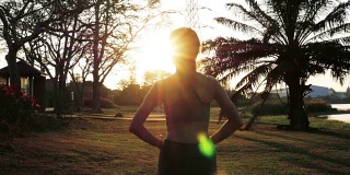 年轻女子锻炼，手臂伸出太阳耀斑