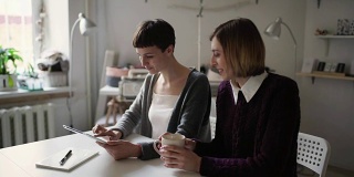 两名女学生在家里使用平板电脑进行在线教育