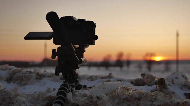 数码单反相机拍摄冬季风景。单反相机拍摄的日落与冬天的自然雪