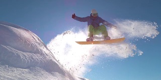 慢动作:专业滑雪板运动员在新雪中跳跃，向太阳喷洒雪花