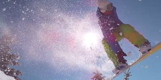 慢镜头特写:激动的滑雪运动员跳过太阳在山的边远
