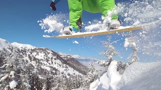 近景:滑雪者在空中跳跃，身后留下一段新雪的痕迹。视频素材模板下载