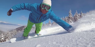 慢动作特写:微笑的滑雪板做手拖在新鲜的粉末雪