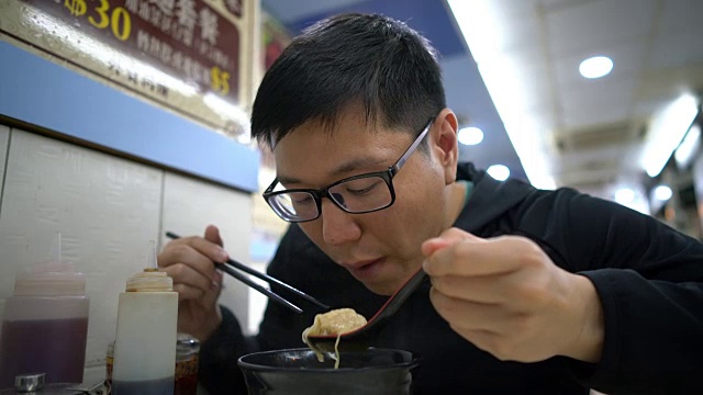 亚洲男子在吃香港馄饨虾面汤