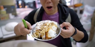 亚洲游客在香港当地餐厅吃米粉卷和粥。
