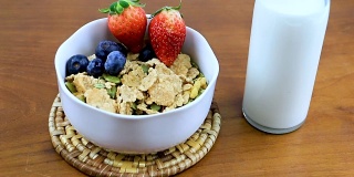 美味营养，轻脆的米片和小麦在碗上的木桌上，与浆果水果，低脂肪更多的蛋白质和叶酸。